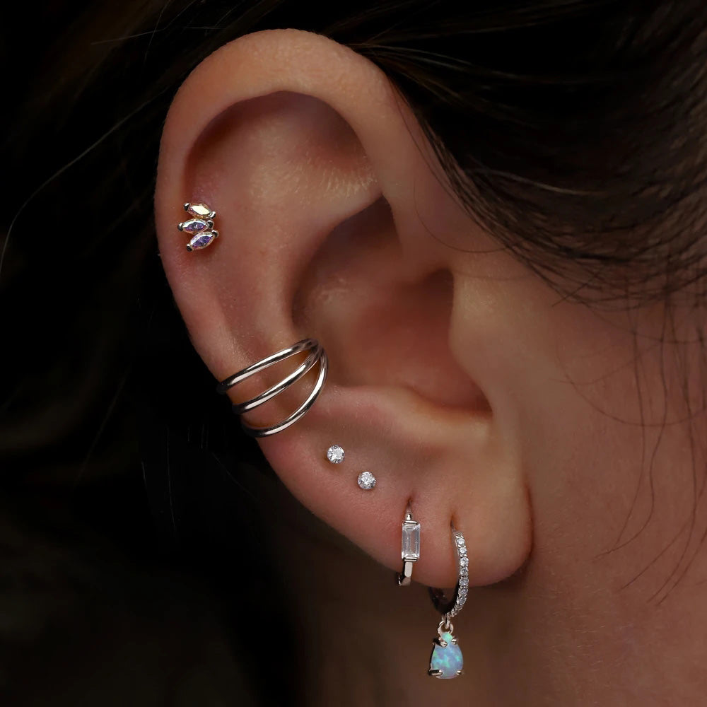 silver triple Earlobe hoop piercing worn by woman