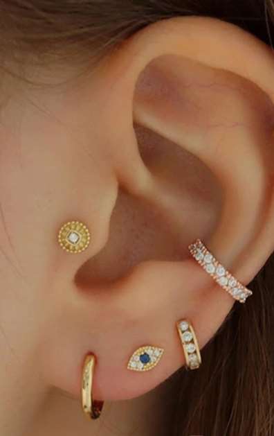 "Woman wearing the Earlobe Eye Piercing in gold finish"