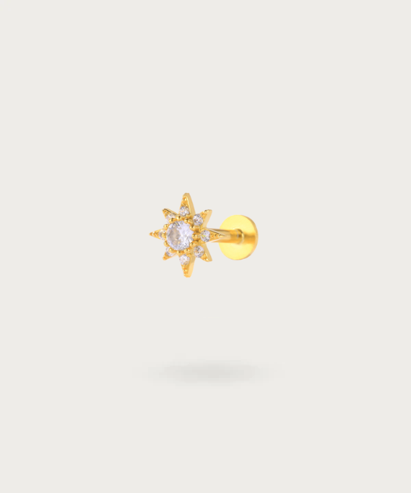 Close-up of the Sun Zircon Forward Helix Piercing, highlighting the brilliant gold details