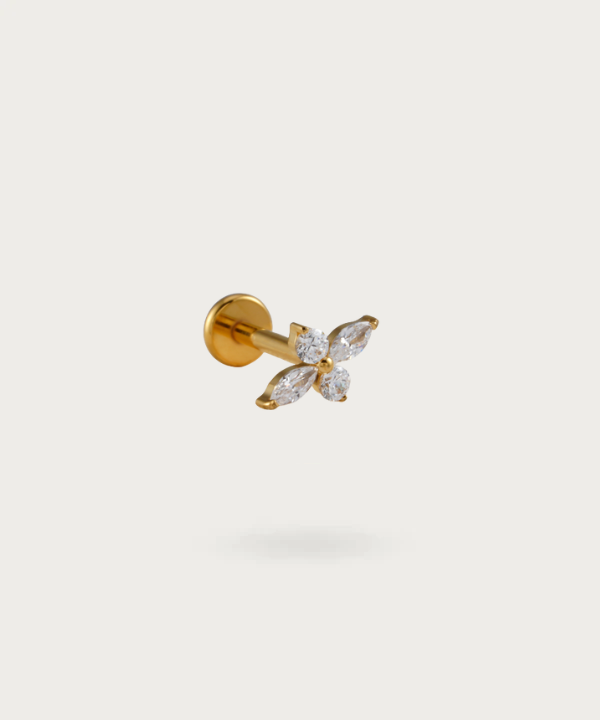 The Forward Helix Flower Piercing on a neutral background, highlighting its delicate floral design. Gold color