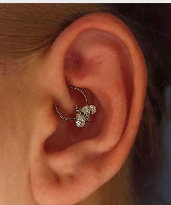 "Silver Bee Hoop Helix Piercing worn on a female ear."