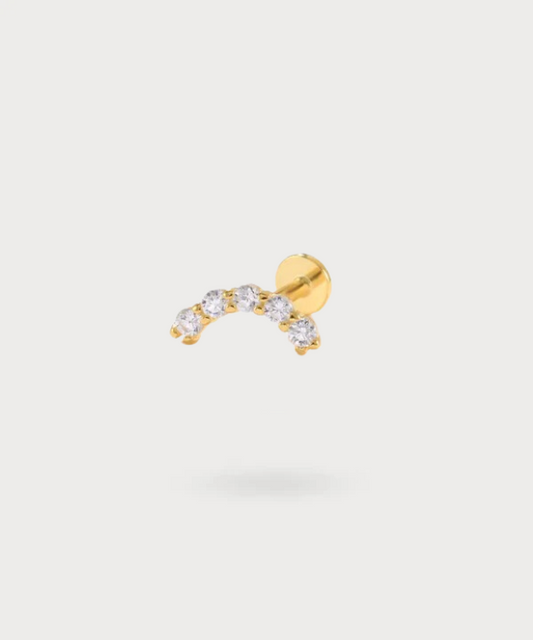 "Lourdes' gold-plated forward helix piercing, illuminated by its sparkling zircons."