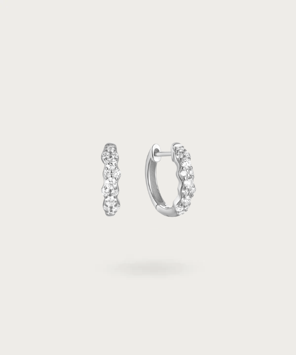 Embark on a light spectacle with Izabel's hoops adorned with varied-sized zirconias.