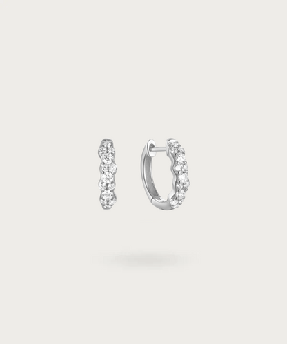 Embark on a light spectacle with Izabel's hoops adorned with varied-sized zirconias.