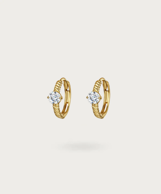 Abril's twisted silver hoop earrings featuring a central sparkling zirconia.