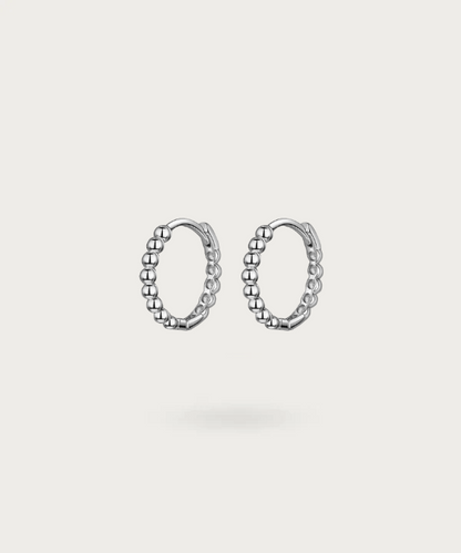 Immerse in Vega's delicate craftsmanship with sterling silver hoops, available in gold or silver finishes.