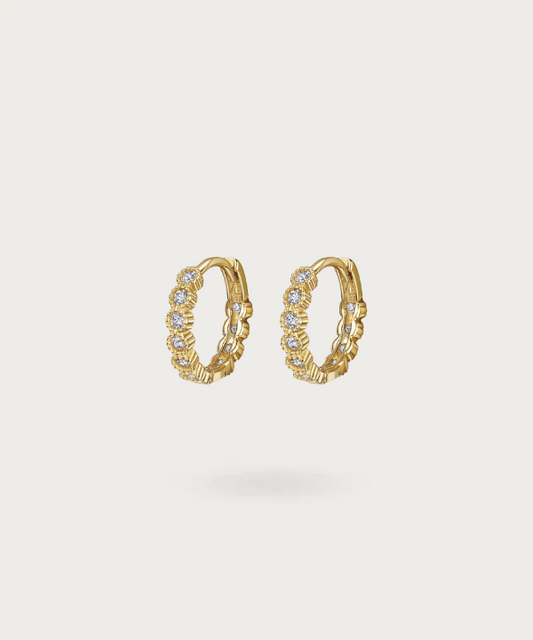 Angelina's silver hoop earrings gleaming with multiple zirconias for a radiant elegance.