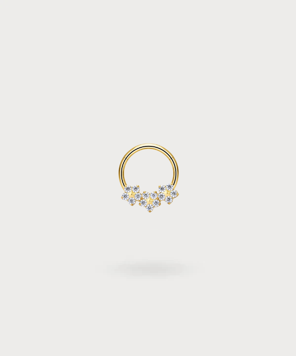 "Olaya Helix Piercing Ring in titanium with a golden finish, decorated with flowers and bright zircons."