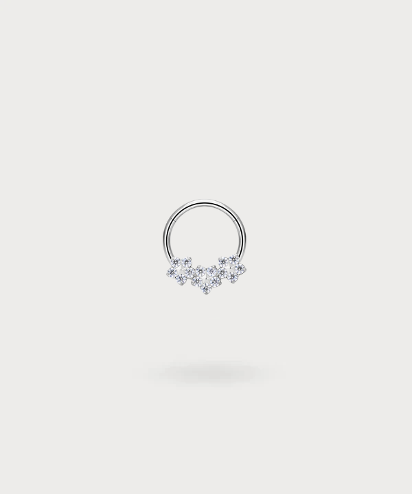 "Olaya Snug Piercing Ring in titanium, silver-toned, with three delicate flowers inset with zircons."