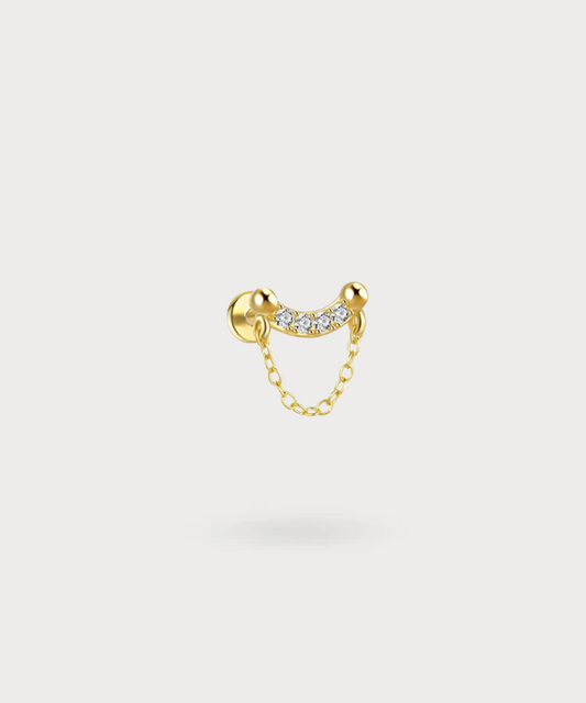 Leticia ear piercing, where zircons and a golden chain unite in elegance