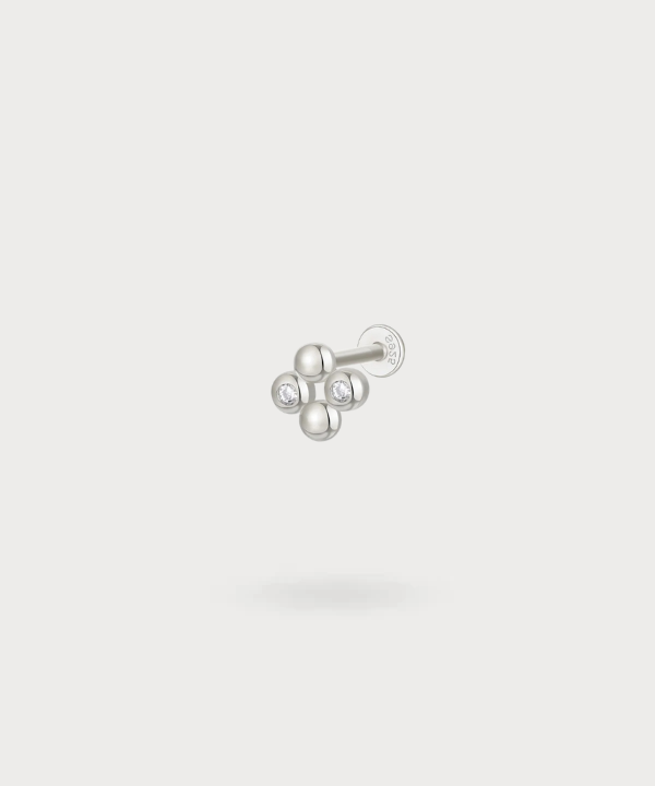 The Erregina tragus piercing, where each sphere and zirconia gracefully capture the light.