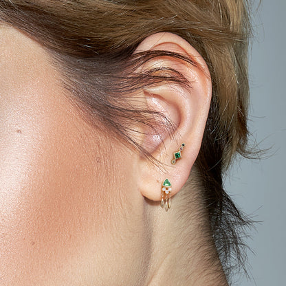 The Marika Bohemian Ear Piercing worn, demonstrating its visual appeal on the emerald-colored ear