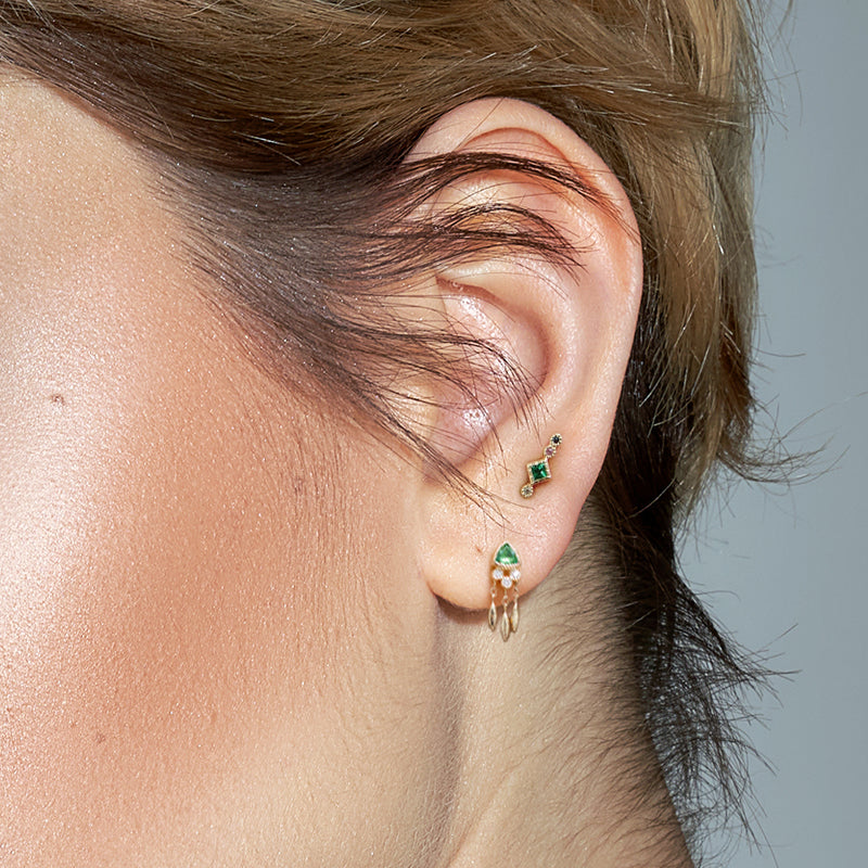 The Marika Bohemian Ear Flat Piercing worn, demonstrating its visual appeal on the emerald-colored ear