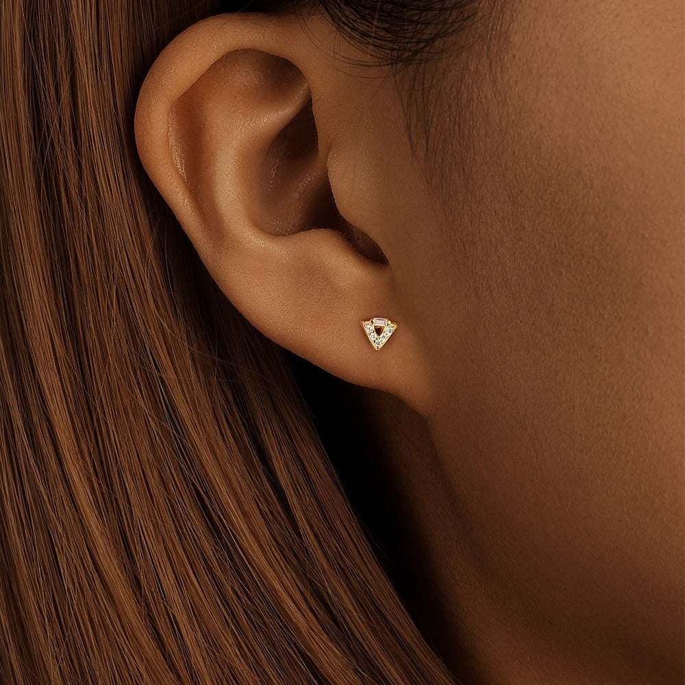 Woman wearing the Auxi piercing in the lobe in gold, also available for the earlobe.

