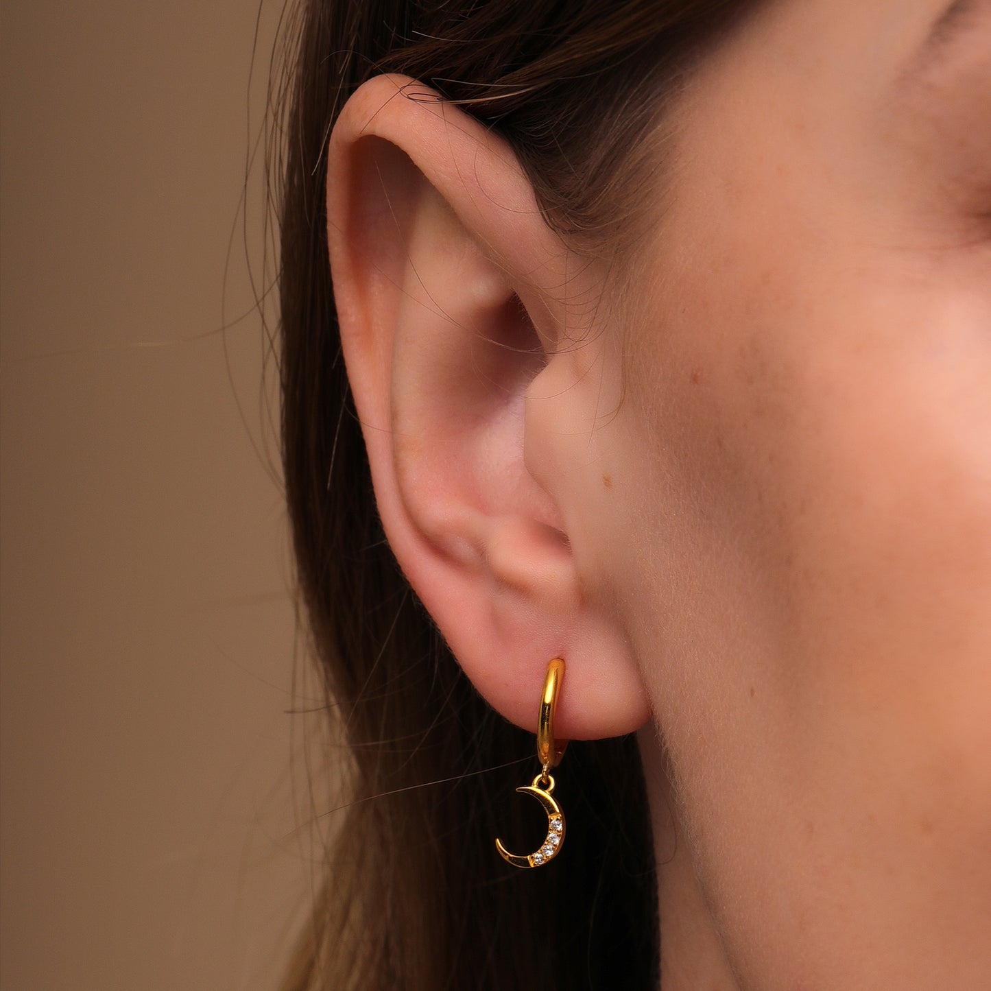 Experience the mesmerizing interplay of day and night with Esther's sun and moon-adorned hoop earrings.