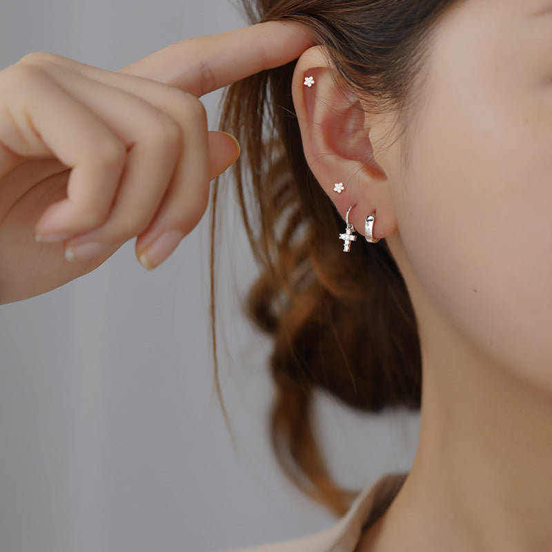 Worn view of the Conch Cross Piercing, demonstrating its unique allure on a female model