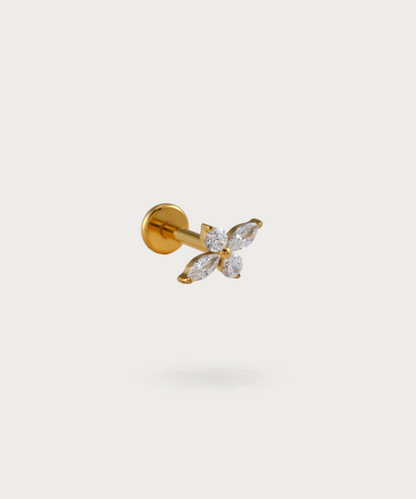 The Tragus Flower Piercing on a neutral background, highlighting its delicate floral design. Gold color